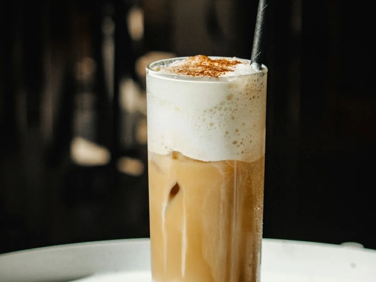 Café frappé maison mousseux dans un grand verre avec paille et glaçons