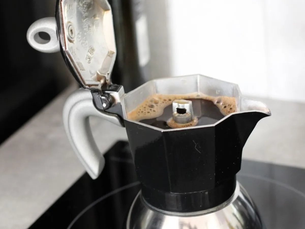 Cafetière italienne moka en train d'infuser un café corsé sur une plaque de cuisson