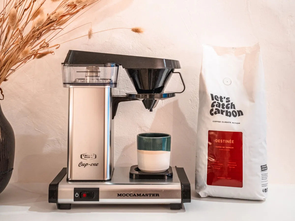 Cafetière Moccamaster Cup-one et paquet de café en grains dans une cuisine lumineuse