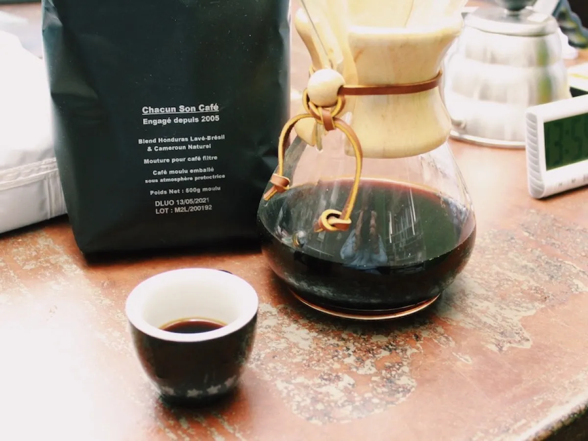 Chemex remplie de café filtre près d'un sachet Chacun Son Café et d'une tasse