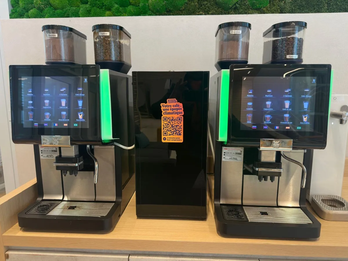 Deux machines à café à grain automatiques à écran et broyeur dans un espace café d'entreprise