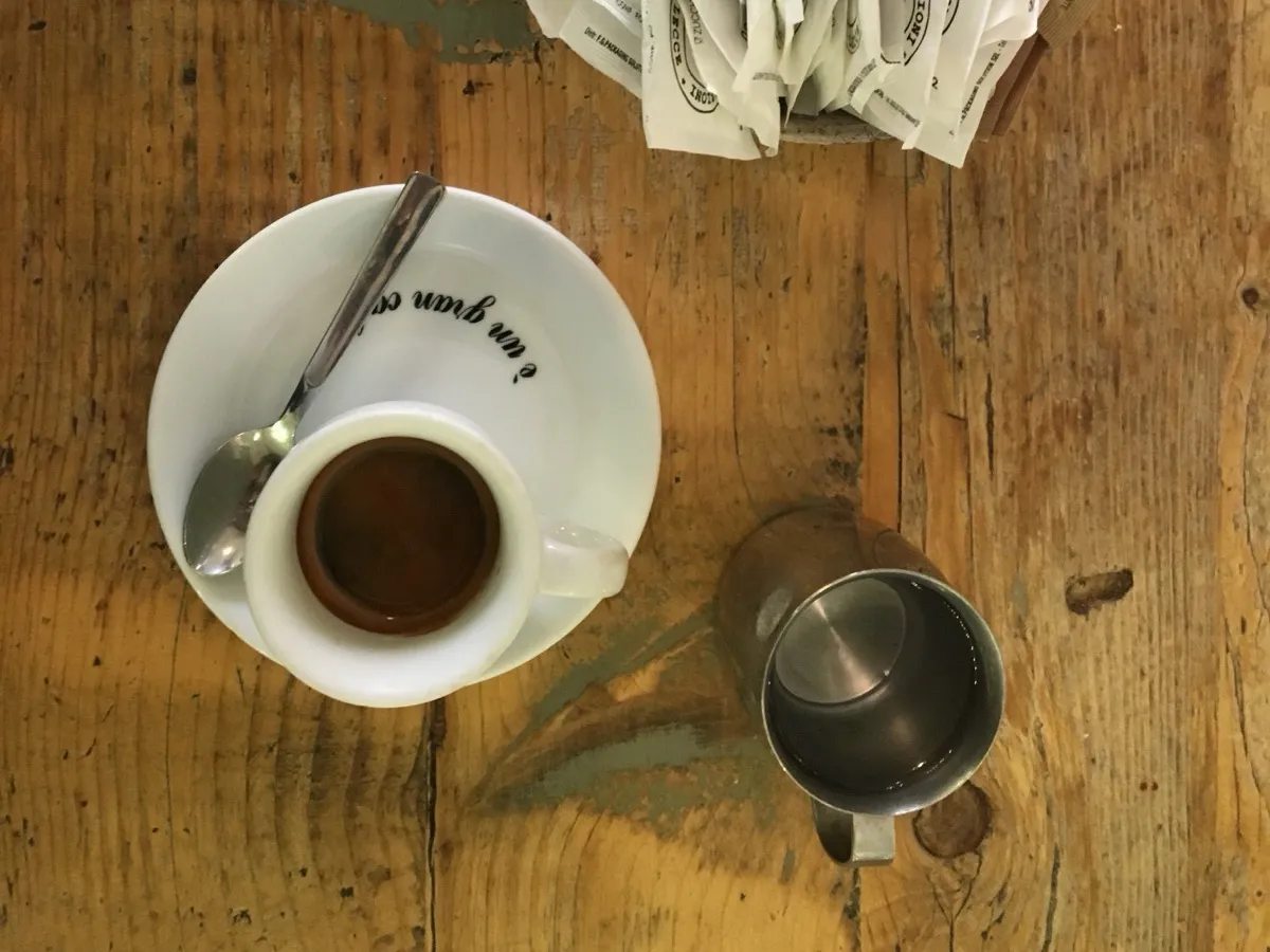 Espresso italien en tasse de porcelaine avec sachets de sucre sur une table en bois