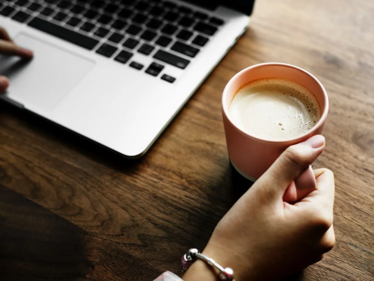 Grande tasse de café au lait près d'un ordinateur, la caféine d'un café dépend de la tasse